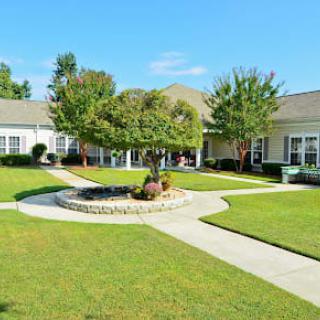 A well-maintained courtyard with a central tree, surrounded by pathways and lawns.
