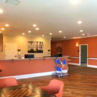 A spacious reception area with a desk, chairs, and warm lighting.