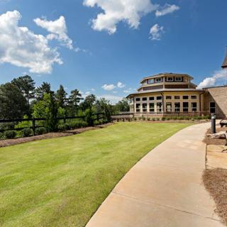 A scenic view of a modern building with a surrounding landscape and clear sky.
