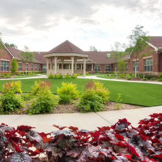 A scenic view of a landscaped garden with a building in the background.