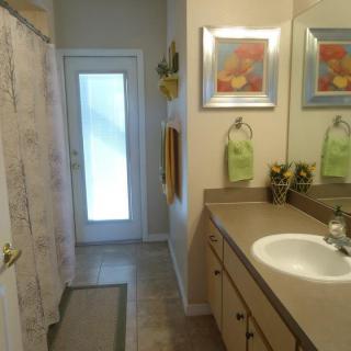 A well-organized bathroom featuring a sink, mirror, and shower curtain with decorative elements.