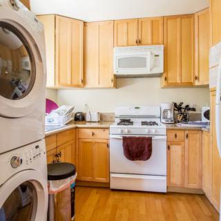 A cozy kitchen with wooden cabinets and integrated laundry appliances.
