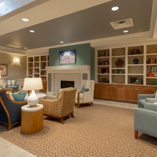 A cozy living room with modern furnishings, featuring a fireplace and built-in bookshelves.