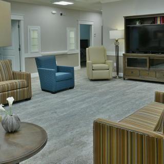 A modern living room with various seating options and a large television.