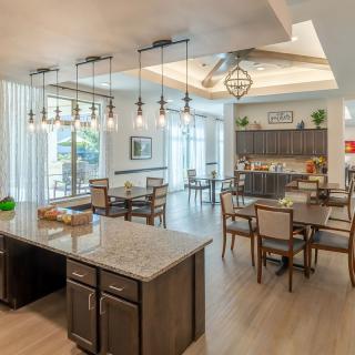 A spacious and modern open concept kitchen and dining area with stylish lighting fixtures.