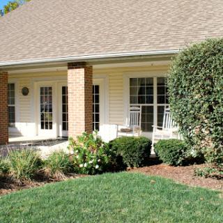 A charming house with a welcoming front porch and well-maintained landscaping.