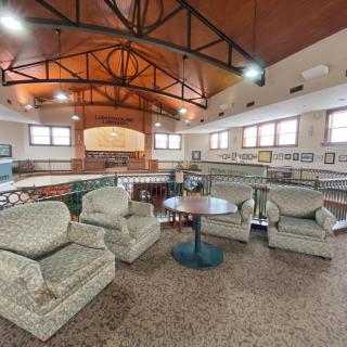 A cozy lounge area with comfortable armchairs and a high wooden ceiling.