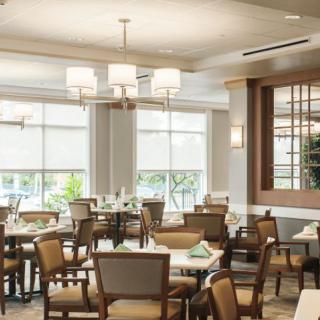 A modern dining room with elegant tables and chairs, featuring stylish lighting fixtures.