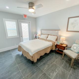 A modern bedroom with a neatly made bed, stylish furniture, and soft lighting.