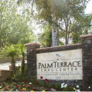 Entrance sign for Palm Terrace Care Center surrounded by greenery.