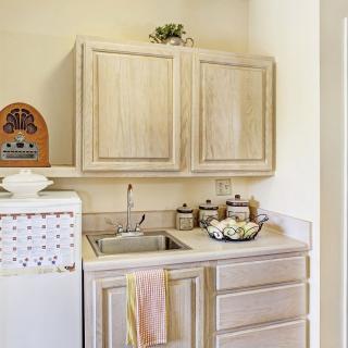 A cozy kitchen corner featuring wooden cabinets, a vintage radio, and ceramic jars on the countertop.