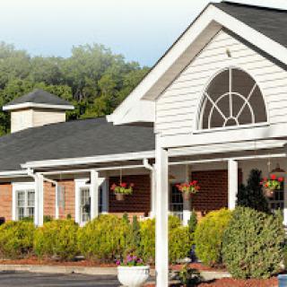 A charming residential building with a welcoming front porch and well-maintained landscaping.