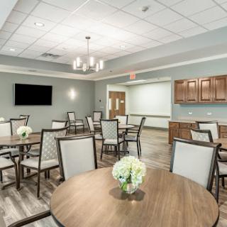 A modern, well-lit dining area featuring tables and chairs, perfect for gatherings or meetings.