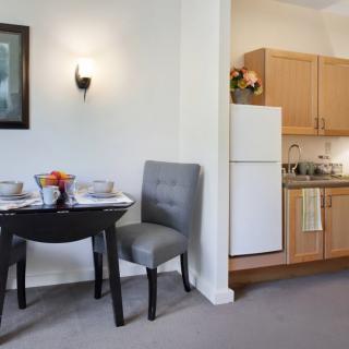 A cozy kitchen and dining area with a small table, chairs, and essential appliances.