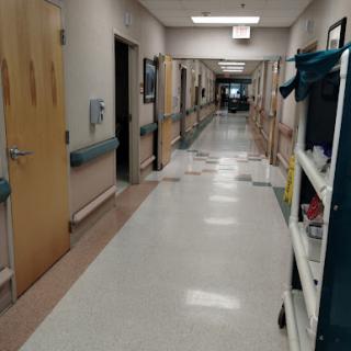 A view of a hospital hallway lined with doors and medical equipment.