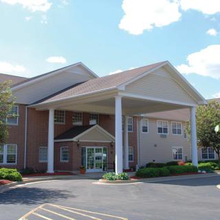 An exterior view of a building with a covered entrance and columns.