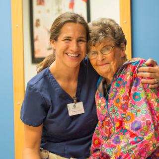 A nurse poses happily with an elderly patient, showcasing the warmth of healthcare relationships.