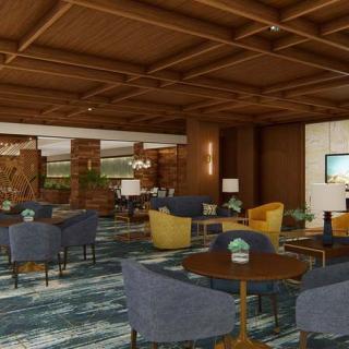 A modern lounge area with a variety of seating options, featuring wooden ceilings and a stylish carpet.