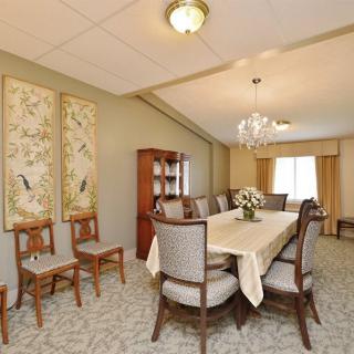 Elegant dining room with a large table, chairs, and decorative artwork.