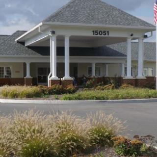 A building entrance with white pillars and landscaped surroundings.