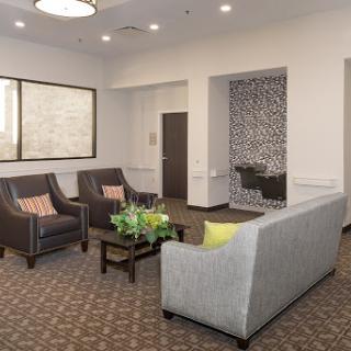 A modern and inviting lobby seating area featuring comfortable furniture and decorative plants.