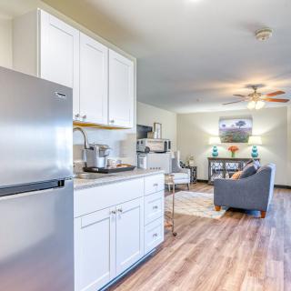 A modern open-concept kitchen and living room with hardwood floors and stainless steel appliances.