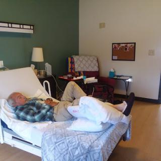 An elderly patient resting in a hospital room, surrounded by medical equipment and a calming environment.