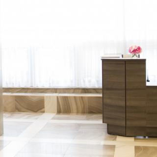 A modern and minimalist lobby with a wooden reception desk.