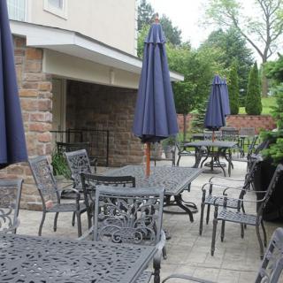 Outdoor patio area with tables, chairs, and umbrellas at a restaurant.