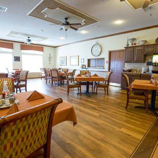 A cozy dining area with neatly set tables and warm lighting.