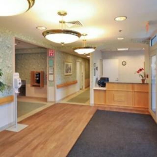 A well-lit lobby and reception area with a desk and hallway.