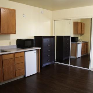 A cozy kitchen area featuring wooden cabinets and essential appliances.