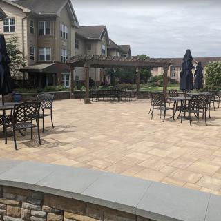 Outdoor patio area with tables and chairs near a residential building.
