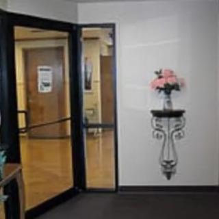 A decorated hallway entrance featuring a glass door and wall-mounted flower arrangement.