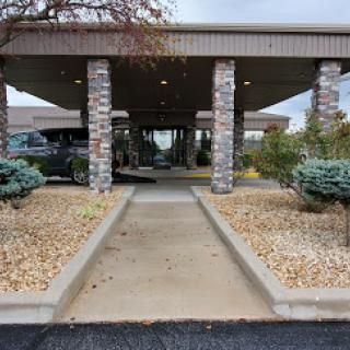 Entrance to a building with landscaped surroundings and a clear pathway.