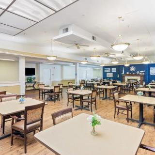 A spacious and well-lit dining area with neatly arranged tables and chairs.
