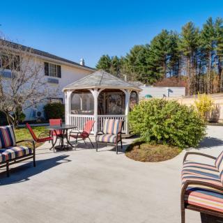 A spacious backyard patio with seating and a gazebo on a sunny day.