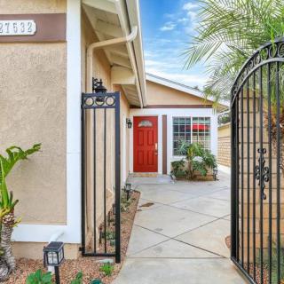 A welcoming entrance to a suburban home with a red front door and black wrought iron gate.
