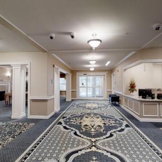 A spacious lobby with a decorative carpet and elegant lighting.