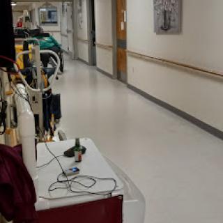 A view of a hospital corridor featuring medical equipment and a clean, well-lit environment.