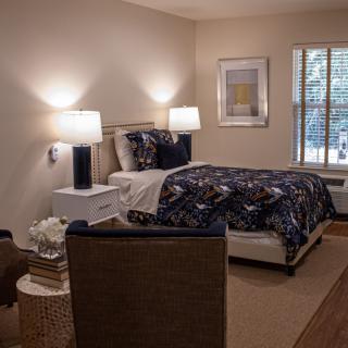 Cozy bedroom with a neatly made bed and warm lighting.
