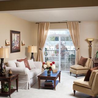 A cozy living room with elegant seating and natural light streaming through the curtains.