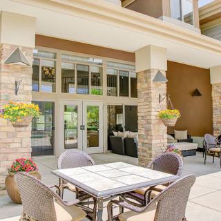 A modern outdoor patio with seating and decorative plants.