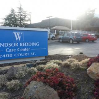 The entrance of Windsor Redding Care Center with a visible sign and parking lot.