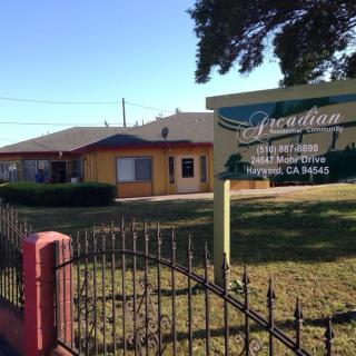 A single-story building with a sign reading 'Travel Inn', surrounded by a fence and lawn.