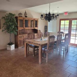 A cozy dining area featuring a wooden table, matching chairs, and a decorative chandelier.