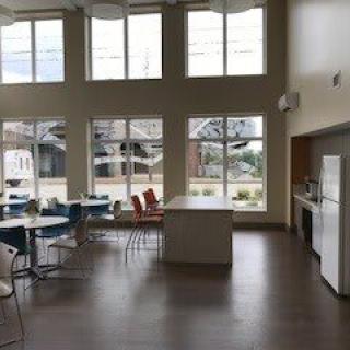 A modern kitchen and dining area with large windows and natural lighting.