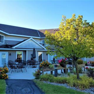A beautiful house with a landscaped garden and patio area on a sunny day.