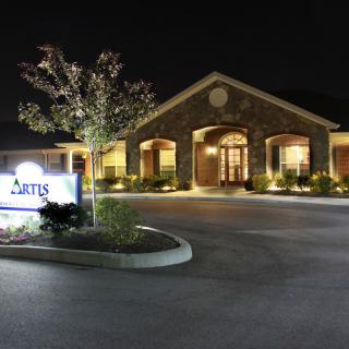 A well-lit building entrance at night showcasing elegant architecture.