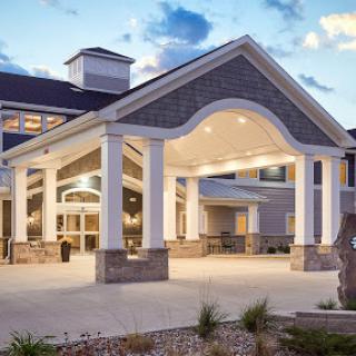 The welcoming entrance of a modern hotel, illuminated under a twilight sky.